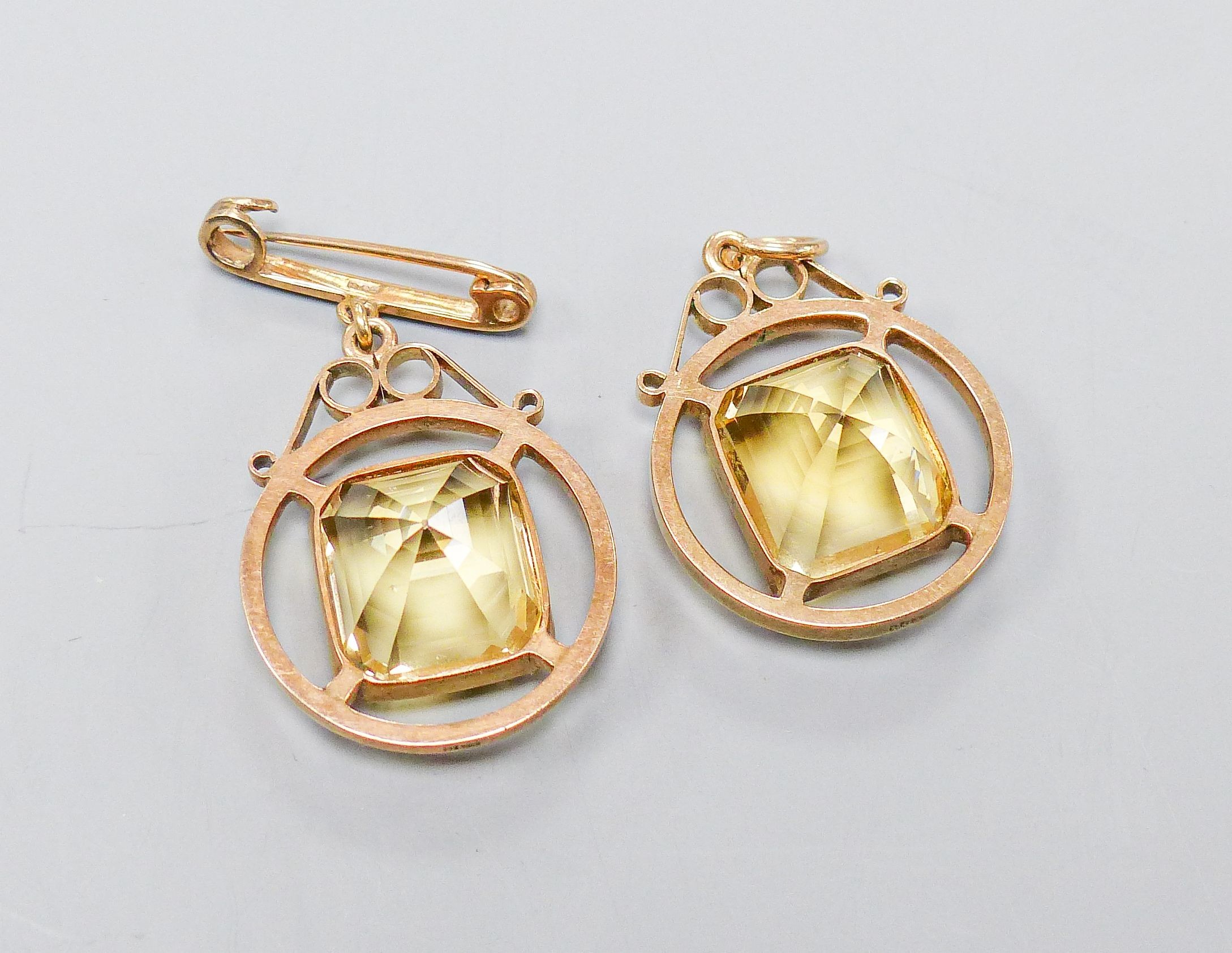 A 9ct mounted step-cut octagonal citrine pendant, 29mm and a matching brooch with suspension pin, gross weight 15.4 grams